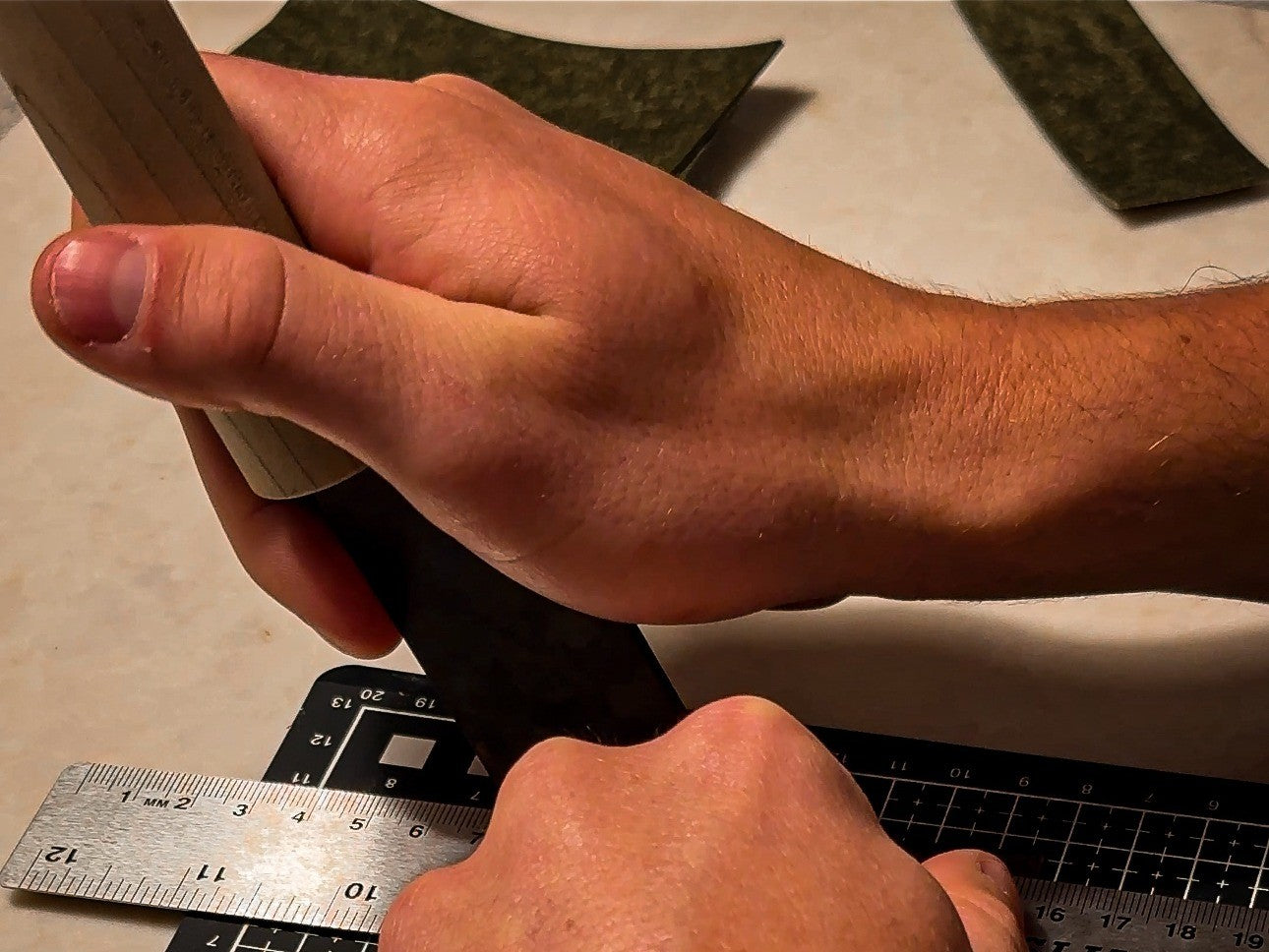 Cutting leather by hand with a blade and ruler