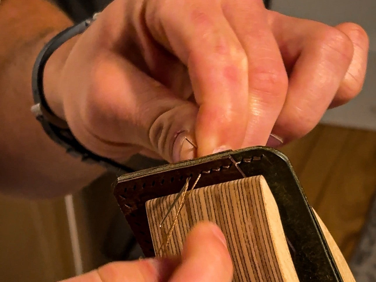 Hand-stitching leather with a needle and waxed thread